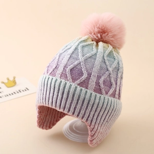 Detailed texture of kids tie-dye knit hat with pompom and earflaps for winter warmth