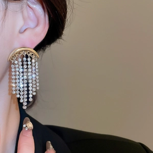 Gros plan détaillé des boucles d'oreilles lune à franges dorées avec des cristaux brillants