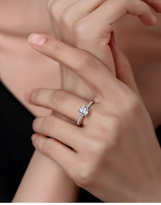 Close-up of s925 silver moissanite ring with six-prong setting and side accent stones