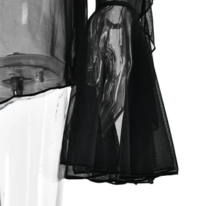 Dettaglio di maniche lunghe in tulle nero trasparente con polsini a campana su abito