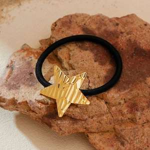 Star-shaped gold metal ponytail holder on stone base for a minimalist aesthetic