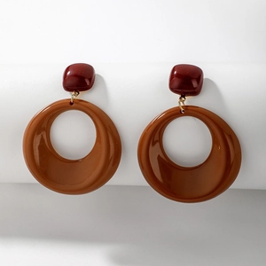 Detail view of retro acrylic earrings with burgundy square and brown geometric ring