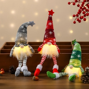 Three glowing Christmas gnomes with LED lights, knitted star hats and dangling legs