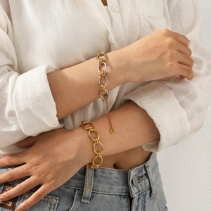 Gros plan d'un bracelet bicolore or et argent avec chaîne réglable et petit pendentif