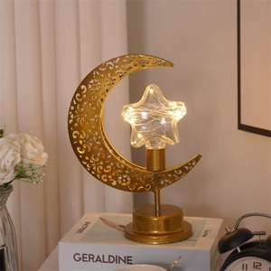 Détail de lampe lune dorée avec ampoule étoile LED sur bureau au décor chaleureux