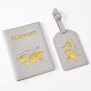 Close-up of gray PU leather passport cover and luggage tag with gold world map stamp