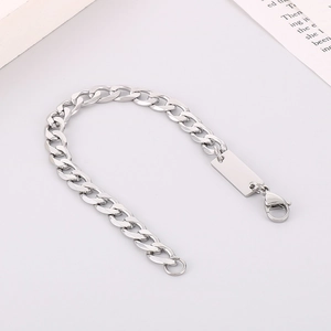 Detailed macro view of 7mm silver NK chain bracelet with a blank rectangular metal tag