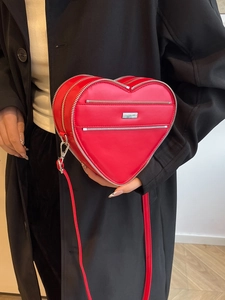 Chic red heart-shaped crossbody leather bag with silver zippers and thin shoulder strap