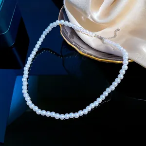 Detail of white pearl necklace with silver lobster clasp and adjustable extension chain
