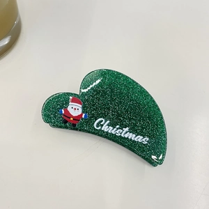 Detail of green glitter Christmas hair claw clip featuring Santa Claus and text