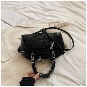 Detail of black faux crocodile leather shell bag with metal ring handles and strap