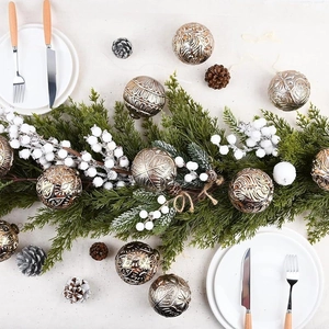 Detailed view of 8cm bronze Christmas balls with embossed patterns and pine needles