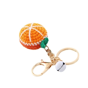 Handmade crochet orange fruit keychain with golden metal ring and a white bell charm