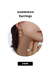 Détail d'une bague en acier doré 18 carats avec nacre blanche portée par un mannequin