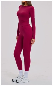 Detail of red high-waist yoga leggings and long sleeve top set with premium fabric texture