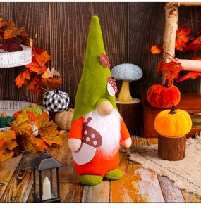 Detailed view of fall-themed plush gnome with maple leaf hat and acorn decorations