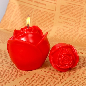 Detailansicht einer realistischen roten Rosenkerze mit feinen Blüten und brennender Flamme