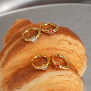 Gold plated stainless steel hoop earrings with red and white zircon gemstones on a croissant