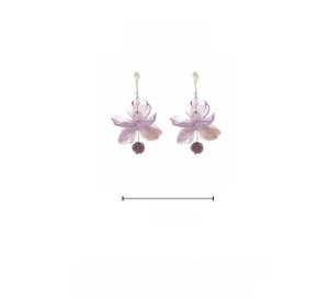 Detail of purple flower tassel earrings featuring resin petals and hanging glass beads