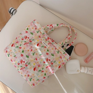 Detail view of pink quilted tote bag with floral tulip print and cosmetic essentials