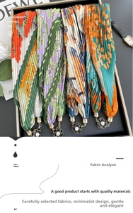 Detail of pleated silk scarves featuring floral prints and camellia pearl pendants