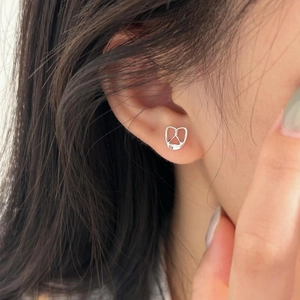 Close-up of polished 925 sterling silver pretzel knot stud earring worn by a model
