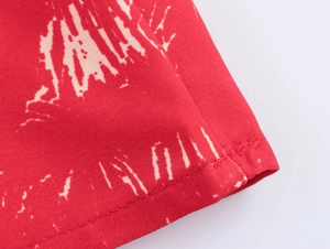 Close-up of red fabric with white coconut tree print showing premium double stitching