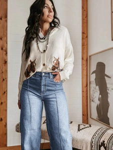 Detail van high-waisted wide-leg jeans met middennaad en vest met paardenprint