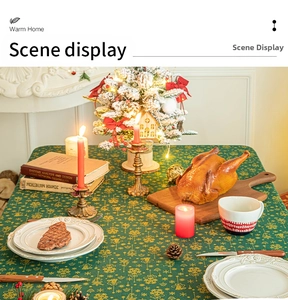 Close-up of green Christmas tablecloth with gold foil snowflake and bell patterns