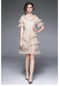 Macro view of champagne lace embroidery and layered ruffles on a luxury dress