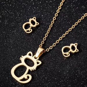 Golden hollow cat jewelry set with necklace and stud earrings on black glitter background