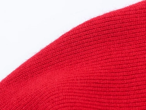 Dettaglio ravvicinato del tessuto a maglia a coste rosse con fibre spesse e morbide