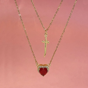 Gold titanium layered necklace featuring sword and red heart pendants with zircon stones