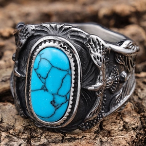 Macro shot of turquoise stone and eagle feather carving on vintage silver ring