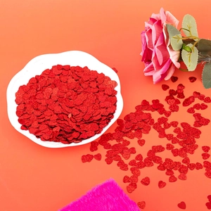Macro shot of red heart glitter sequins and laser confetti for party table decorations