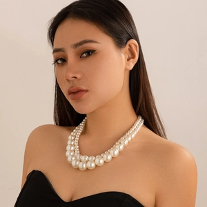 Detailed close-up of double-layer faux pearl necklace on model in elegant vintage style