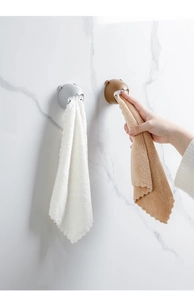 Detail of bear shaped towel holder mounted on marble wall with grey and brown silicone hooks