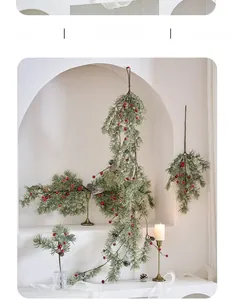Close-up of artificial Christmas pine branch with red berries and pinecones for festive decor