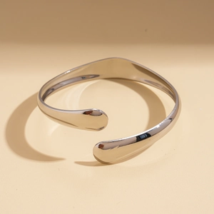 Polished silver irregular oval open bangle with minimalist teardrop ends and mirror finish