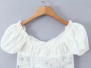 Détail des manches bouffantes en dentelle blanche et de l'encolure à volants élastique