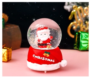 Detail of Christmas crystal ball with Santa Claus figurine and red holiday base decoration
