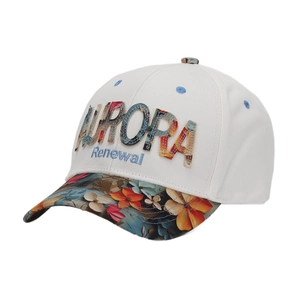 Close-up of floral embroidery and Aurora text details on cream canvas baseball cap