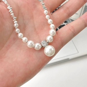 Macro shot of a pearl and rhinestone necklace with shimmering silver accents and beads