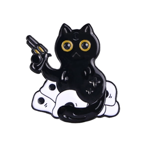 Detail of black cat enamel pin with golden outlines holding a gun on white ghosts