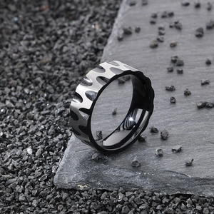 Macro detail of wave patterned titanium steel ring for men on a dark slate background