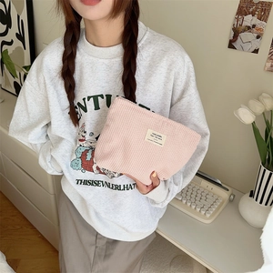 Detail of pink corduroy pouch being held, featuring the Today Zakka label and soft texture