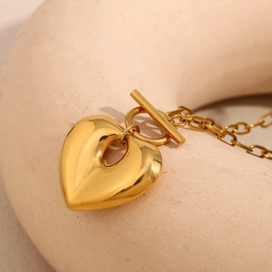 Dettaglio del ciondolo a cuore traforato placcato oro 18K con chiusura a T su ceramica
