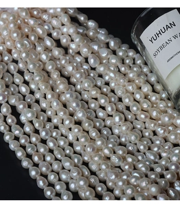 Macro detail of 6.5-7mm natural baroque pearls with authentic texture on black background