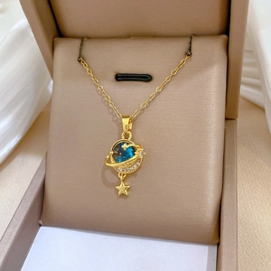 Close-up of a gold starry planet necklace with a blue stone and sparkling zircon stones