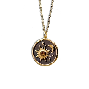 Detailed view of bohemian sun and moon celestial pendant with a vintage golden finish